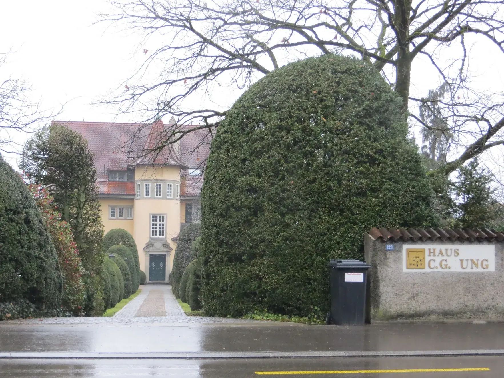 The C.G. Jung House in Küsnacht, a yellow villa behind tall clipped hedges