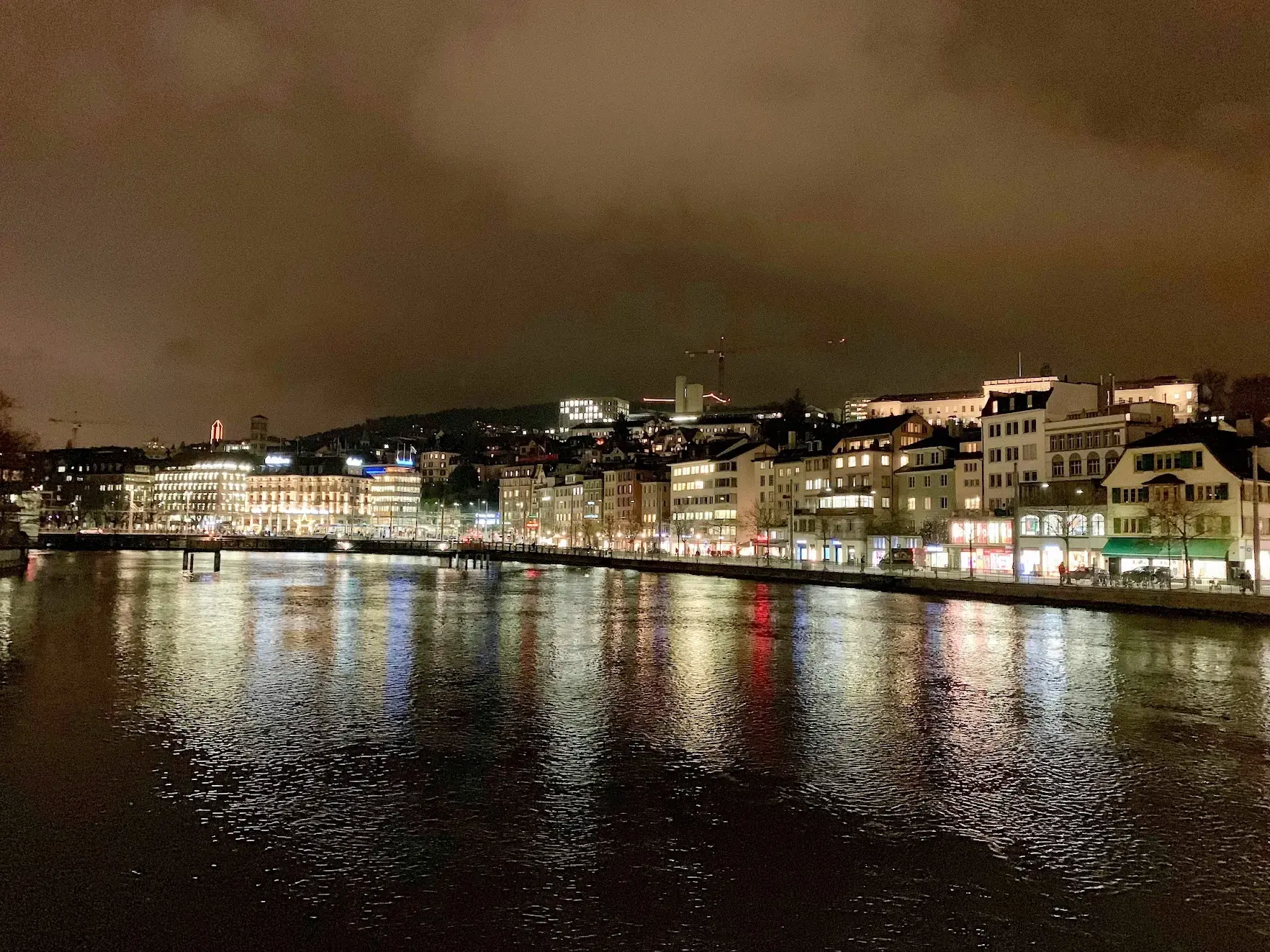 The Limmat river in Zurich at night, with lit buildings reflected in the water