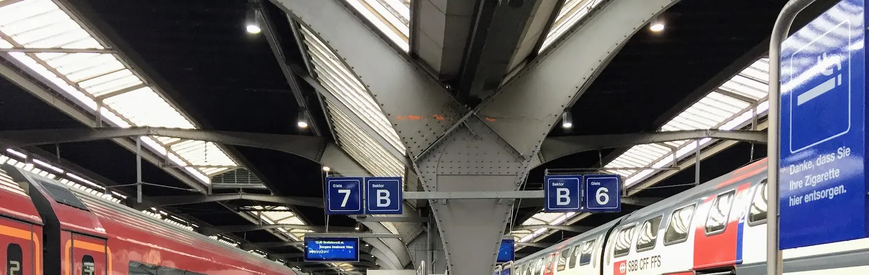 Zurich main station platforms 6 and 7 under the steel roof, with trains on both sides