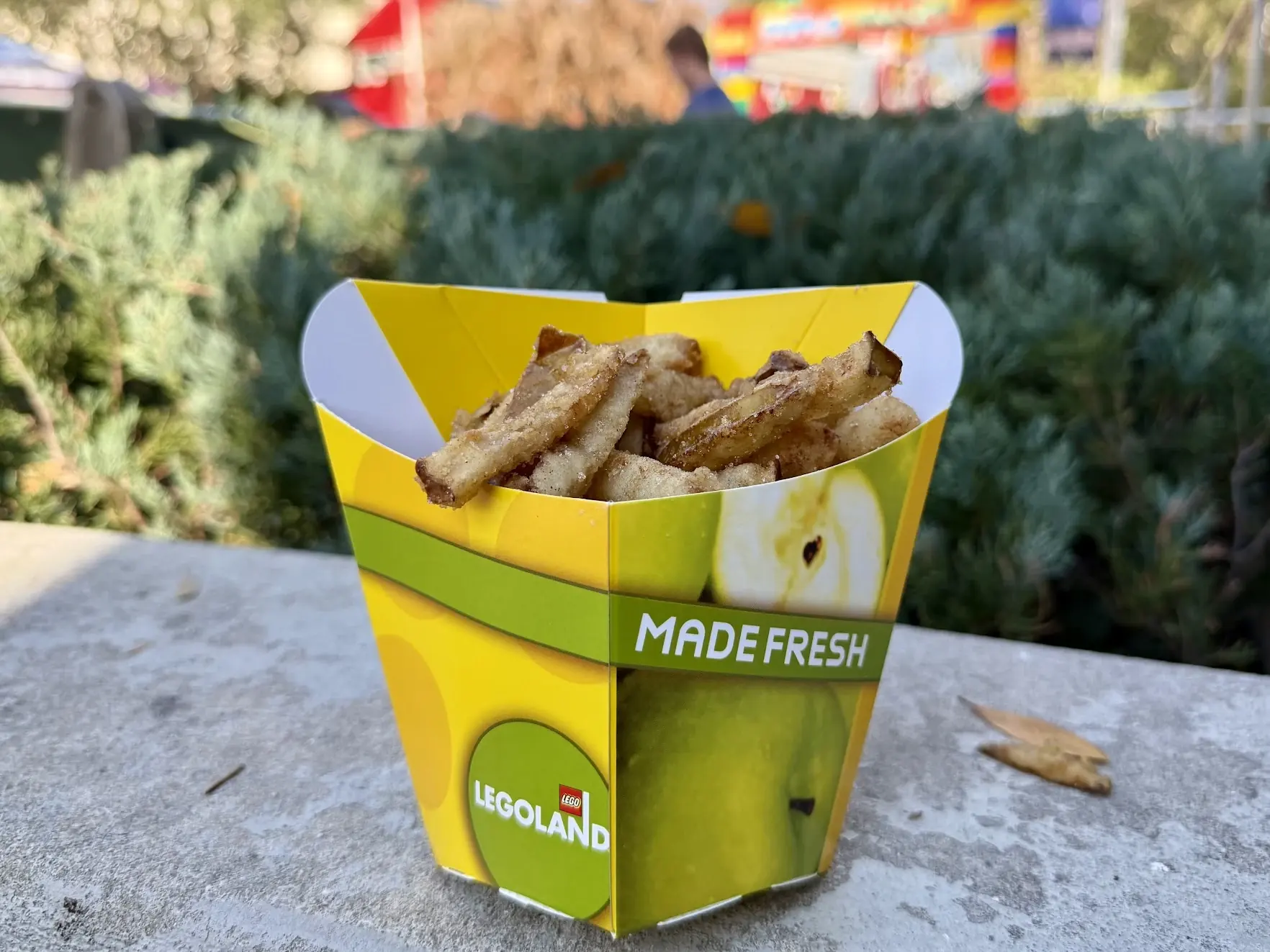 A yellow Legoland cup filled with cinnamon-sugar apple fries