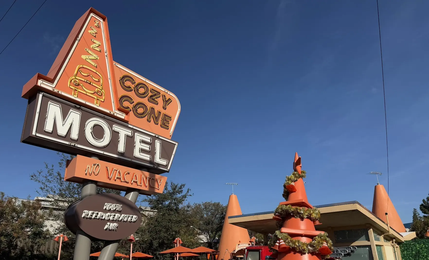The Cozy Cone Motel sign in Cars Land, with a Christmas tree made of traffic cones