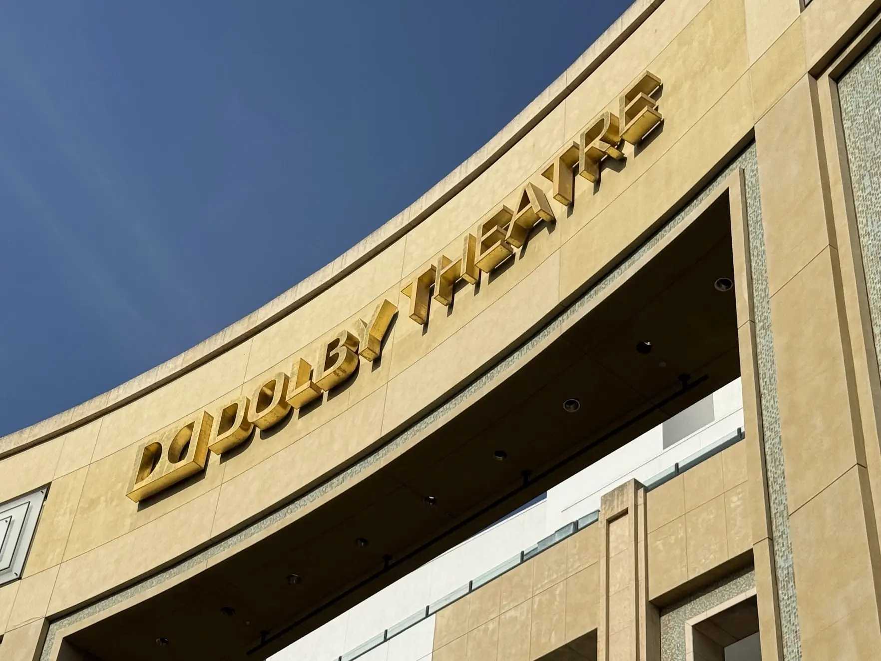 Gold lettering of the Dolby Theatre sign against a blue sky
