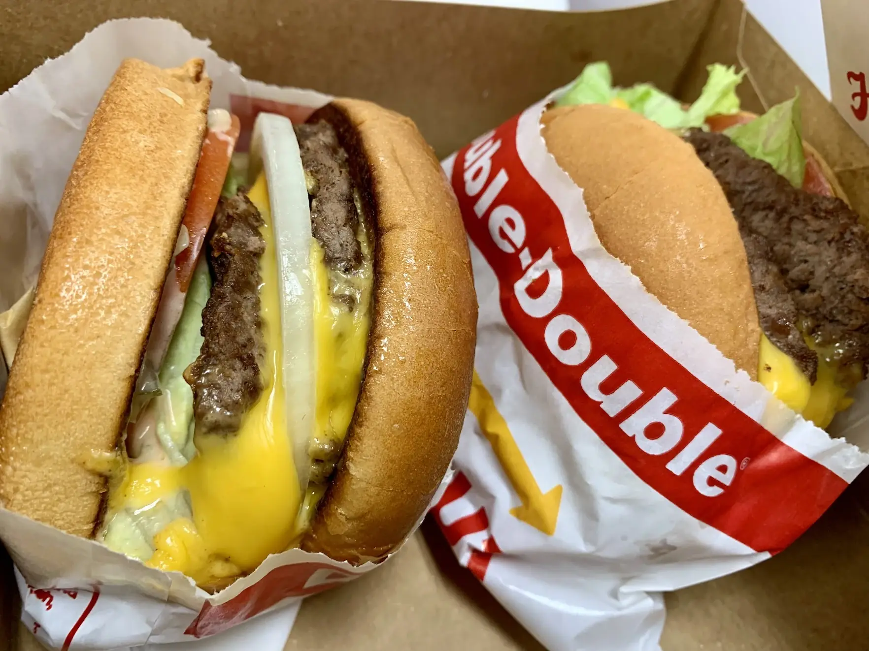 Two In-N-Out Double-Double burgers in their paper wrappers