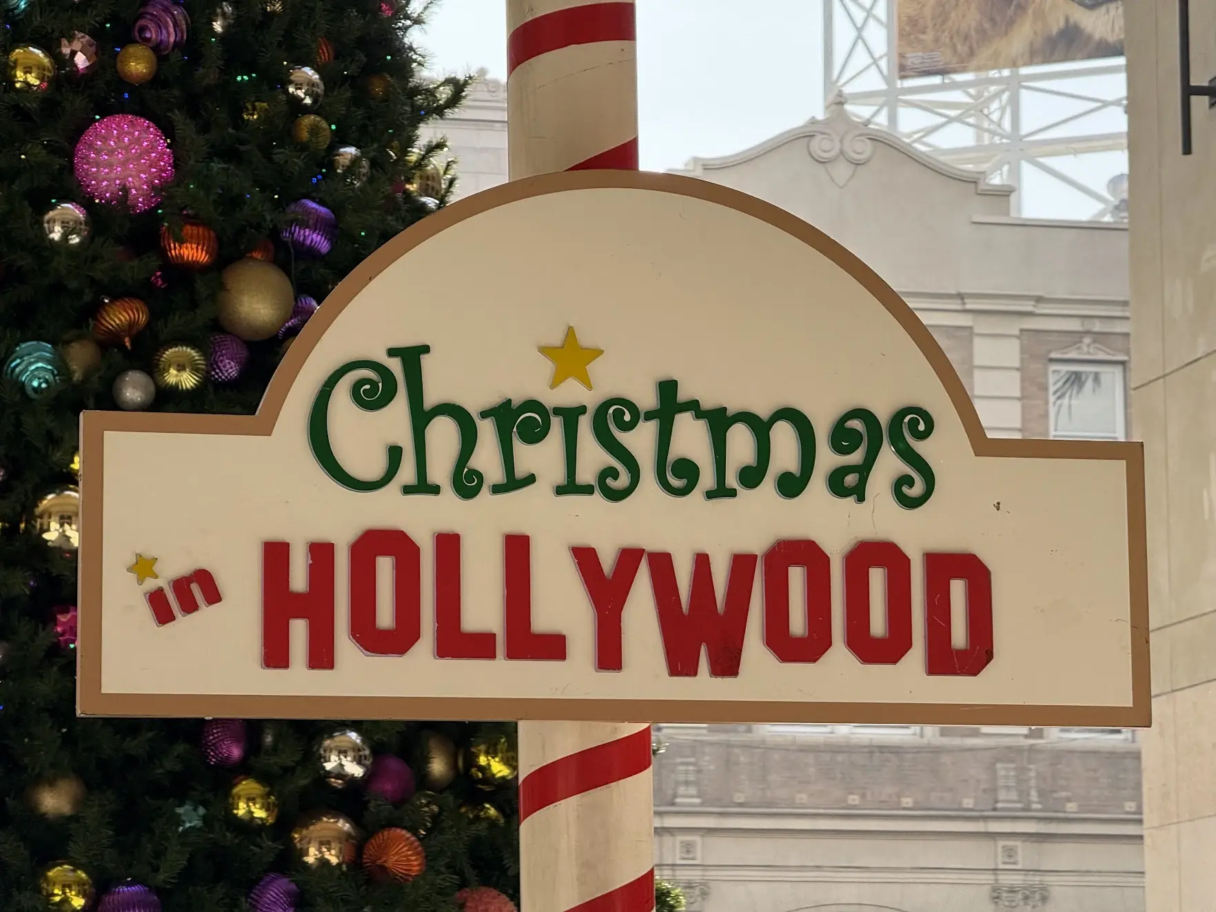 A Christmas in Hollywood sign in front of a decorated Christmas tree